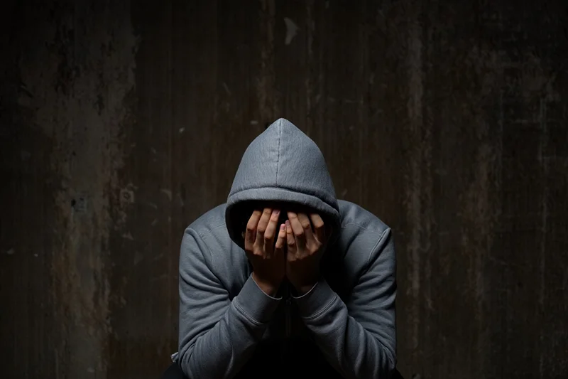 Мужчина сидит с закрытым лицом